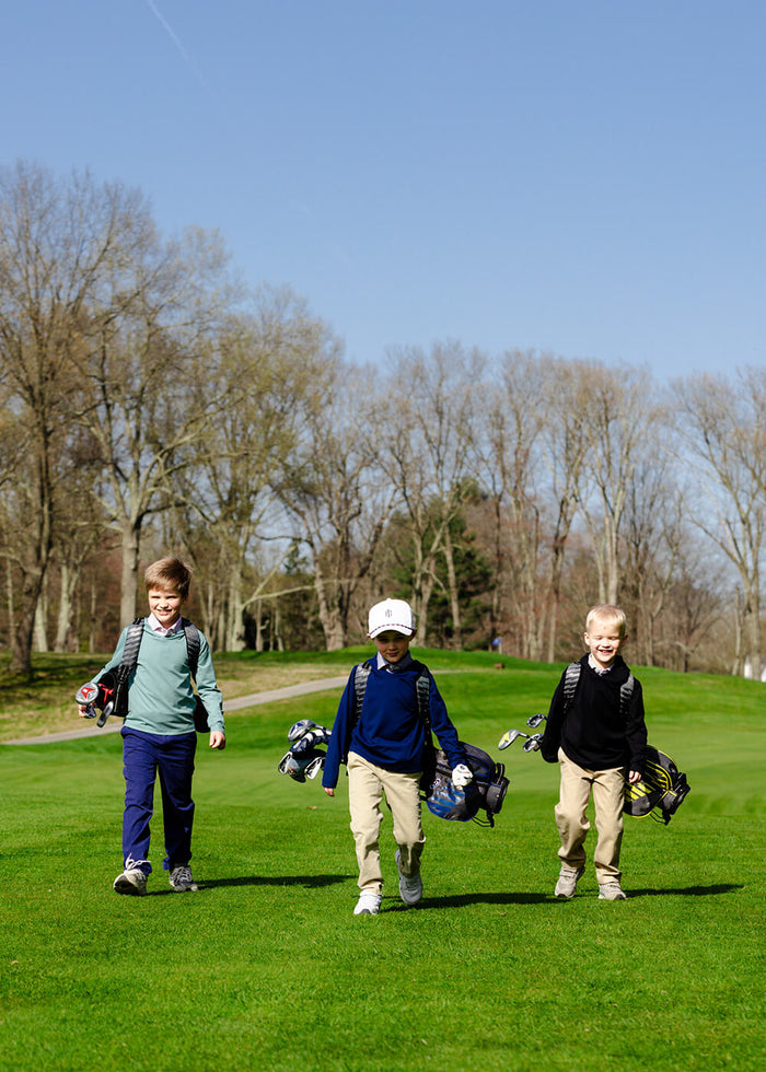 Boys wearing golf clothes on a golf course