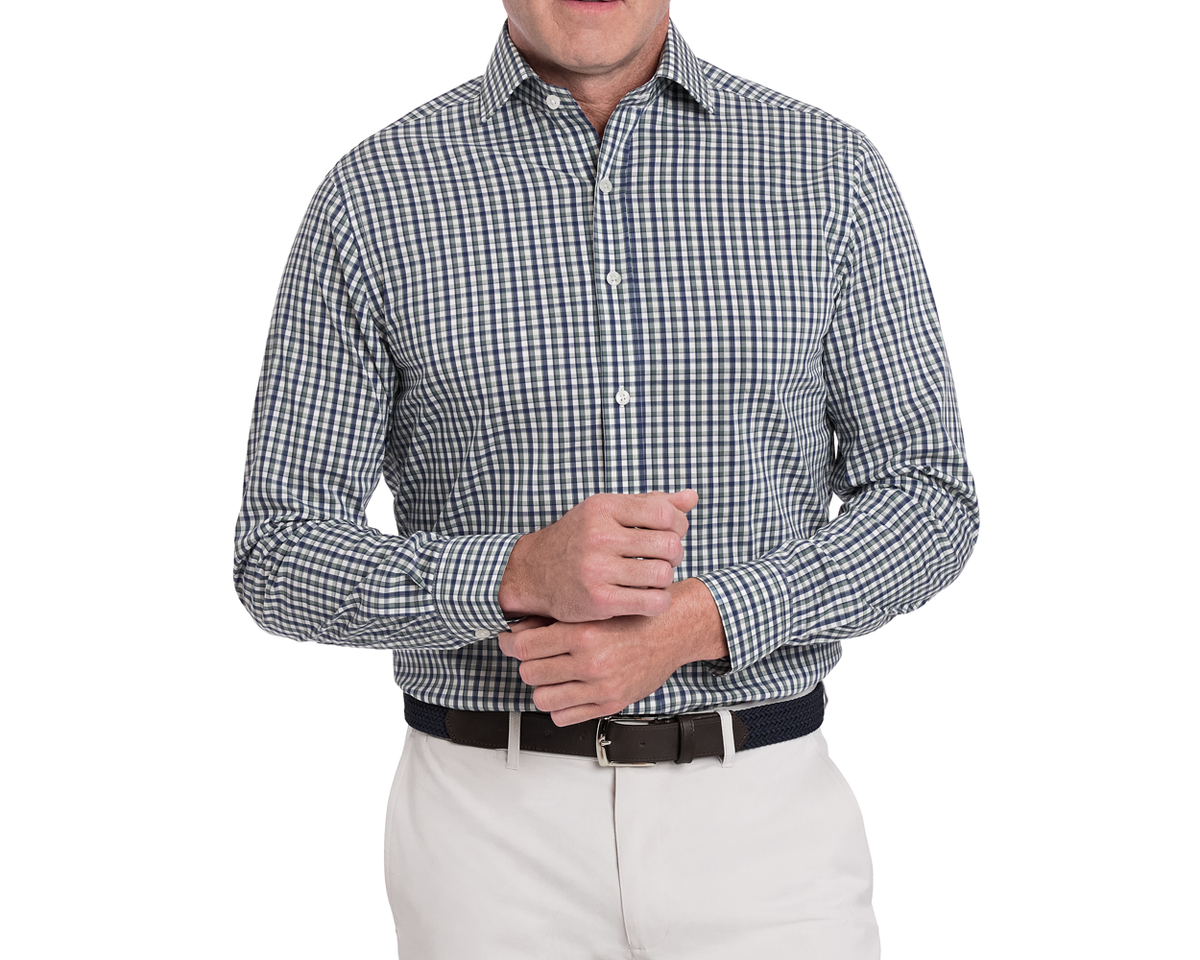 Man wearing a checkered button up shirt and white pants on a white background