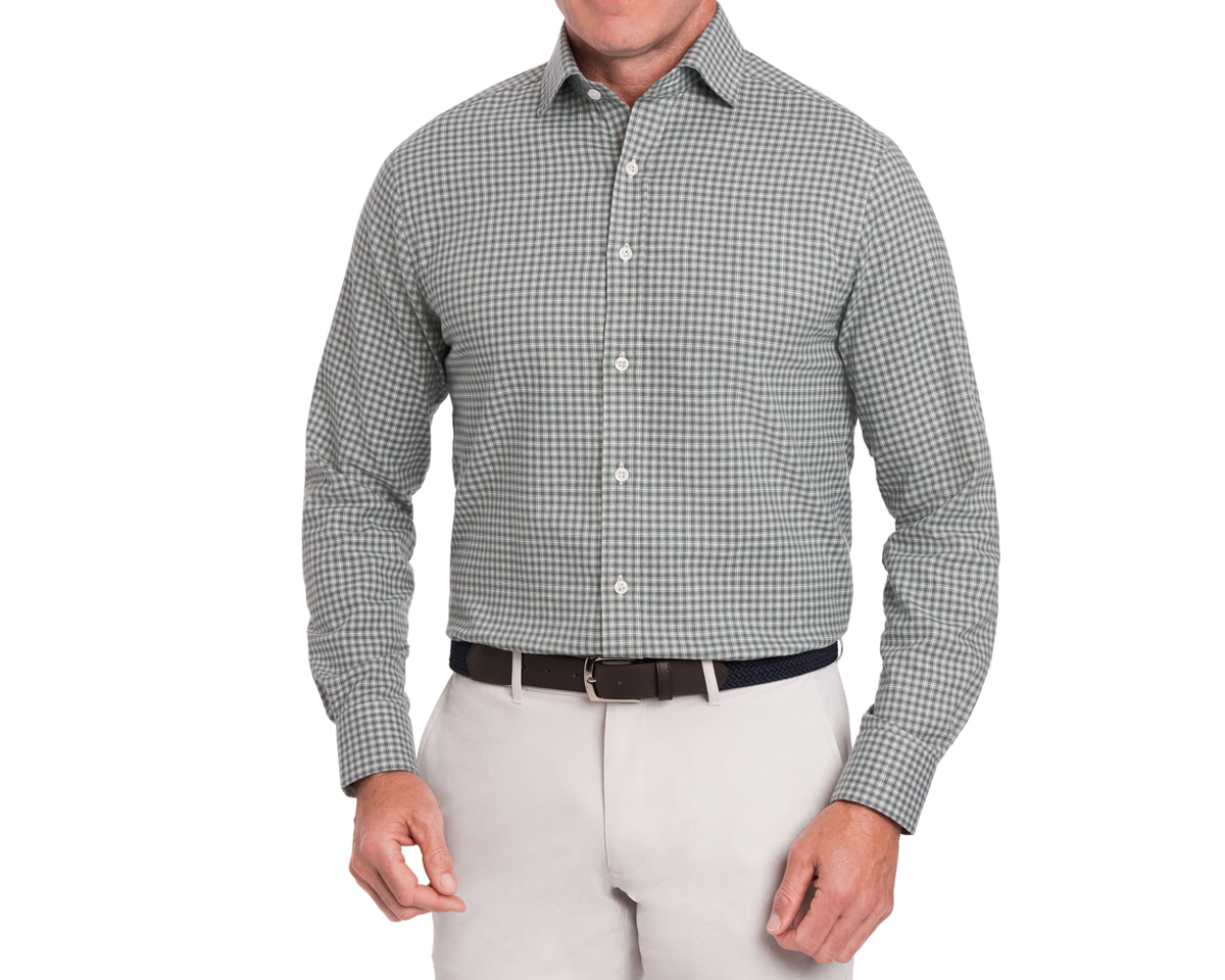 Man wearing a green checkered long sleeve shirt and beige pants on a white background