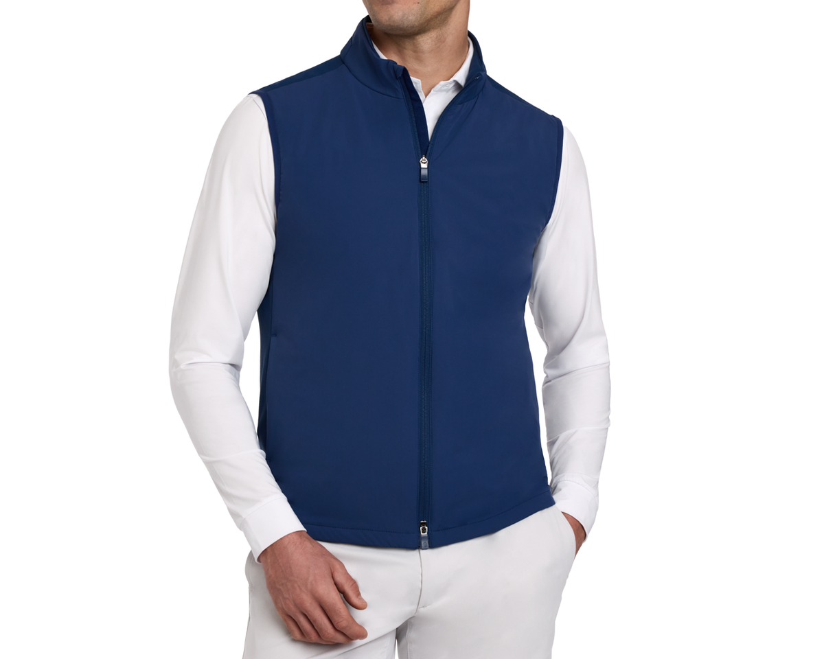 Man wearing a Holderness & Bourne Men’s Blue Golf Vest over a white shirt on a white background