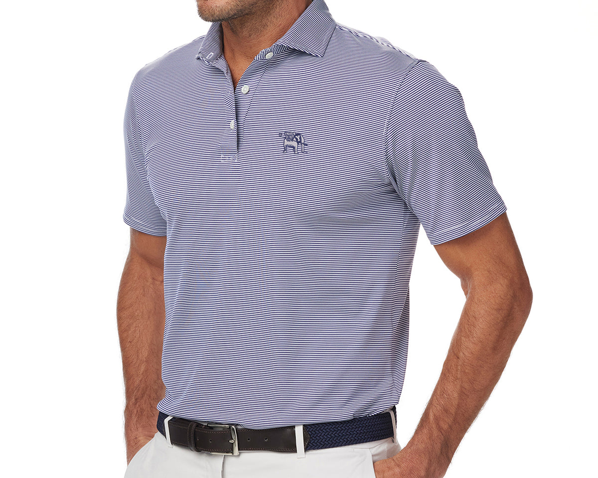Man wearing Yale Golf Course Perkins Shirt: Navy & White, featuring slim-fit, fine stripes, three-button placket, and embroidered elephant logo, paired with light trousers.