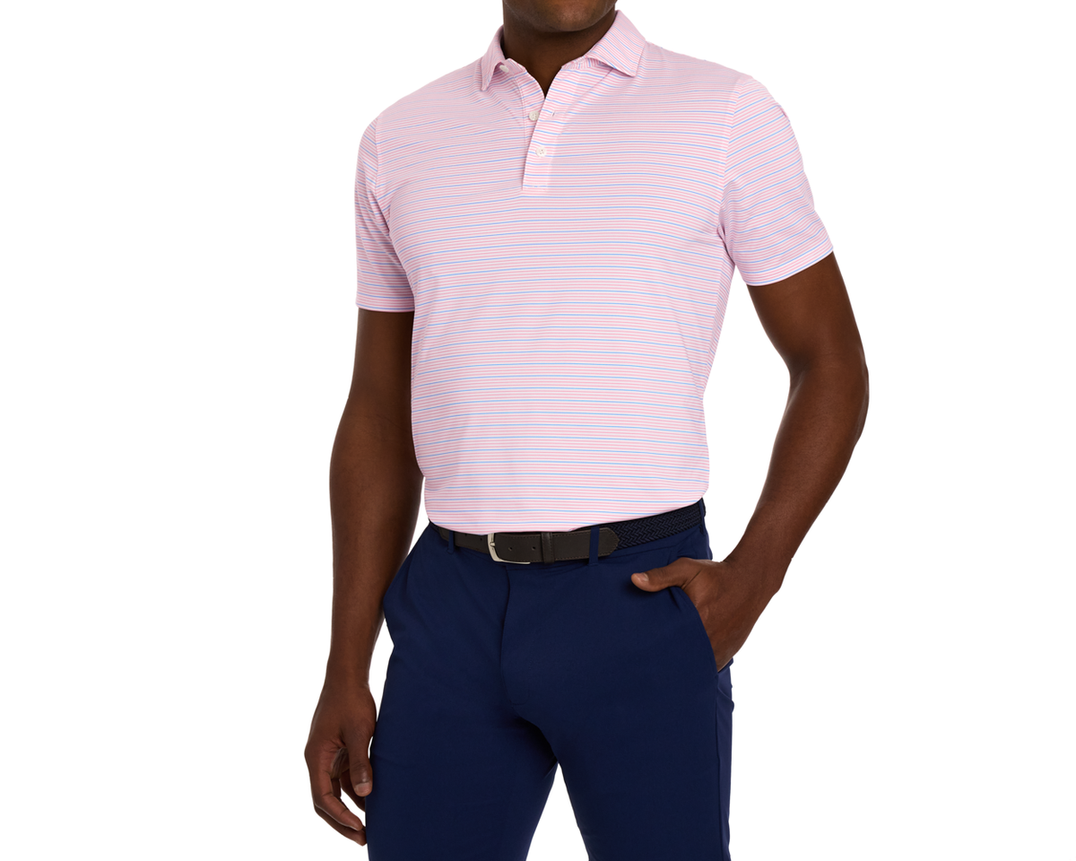 Man modeling The Stanley Shirt: White/Belmont/Horizon Blue, a pastel pink polo with fine stripes, micro perforations, and a spread collar, paired with slim-fit navy pants.