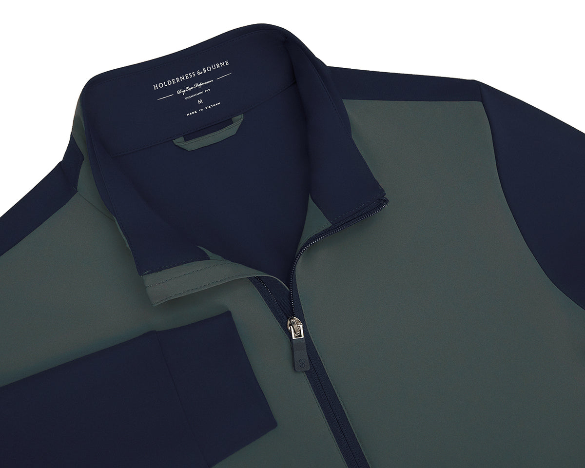 Green and navy golf jacket with brand label on a white background