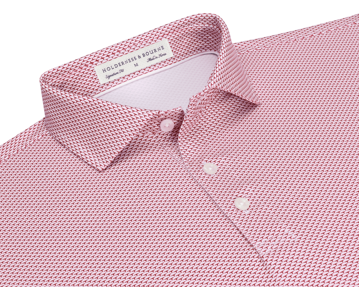 The Armfield Shirt: Liberty Red, featuring a red-and-white geometric print, classic point collar, three-button placket, and Holderness & Bourne label, ideal for golfing performance.