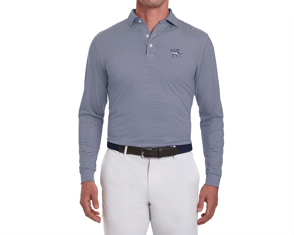 Man wearing Yale Golf Course Burke Shirt: Navy & White, featuring fine stripes, embroidered bulldog logo, tucked into white trousers with dual belts.