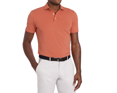 Person wearing Holderness & Bourne Men’s Orange Polo Shirt and white pants.