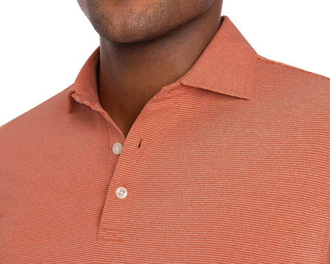 Close-up of a person wearing a Holderness & Bourne Men’s Orange Polo Shirt