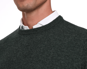 Holderness & Bourne Men’s Dark Green Cashmere Sweater worn over a white shirt on a plain background