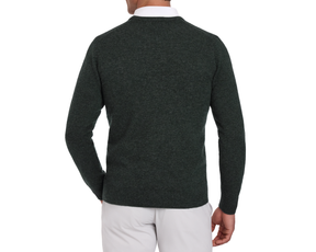 Man wearing a Holderness & Bourne Men’s Dark Green Cashmere Sweater over a white shirt on a white background