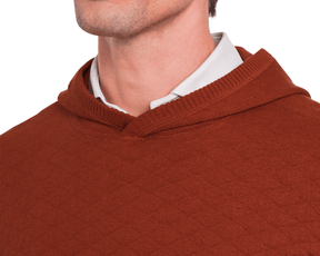 Close-up of a person wearing Holderness & Bourne Men’s Rust Sweater with a white shirt underneath on a white background