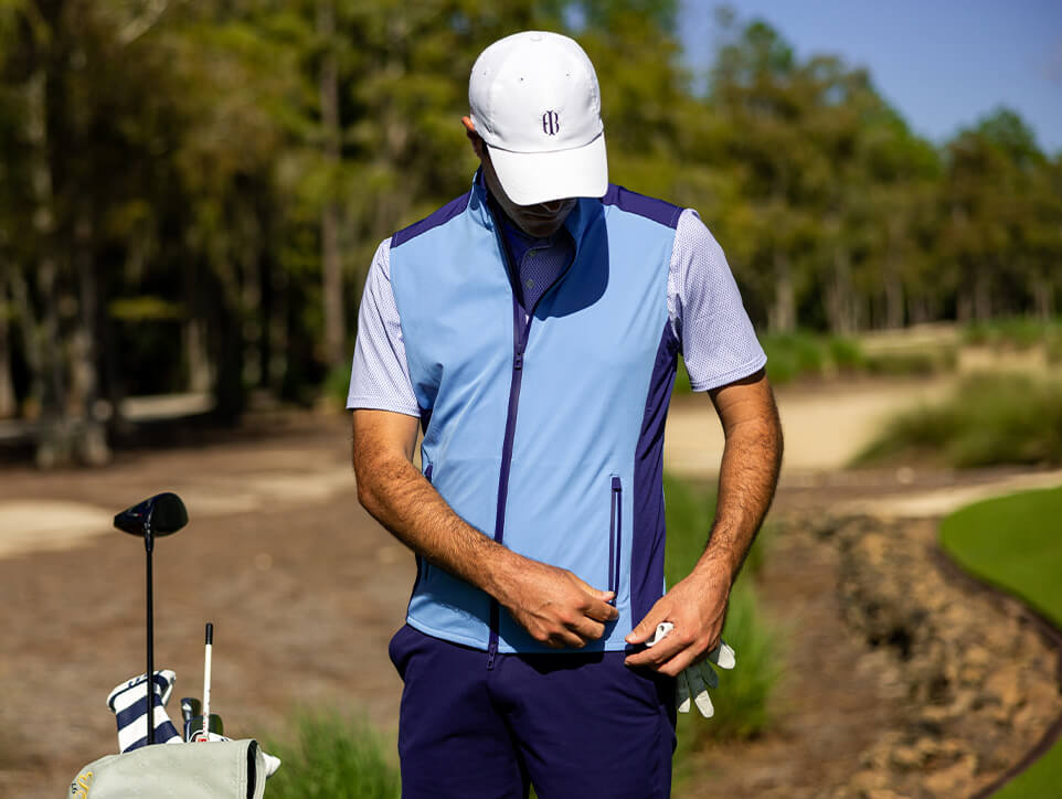 Golfer wearing blue vest on the golf course