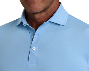 The Anderson Shirt: Vista Blue, featuring a structured spread collar and two-button placket, offers stretch and moisture-wicking for comfort on and off the course.