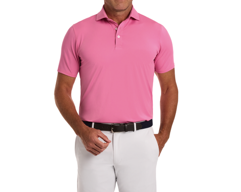 Man wearing The Anderson Shirt: Belmont, a short-sleeve polo with spread collar, tucked into light trousers, showcasing its jersey knit performance fabric and signature fit.