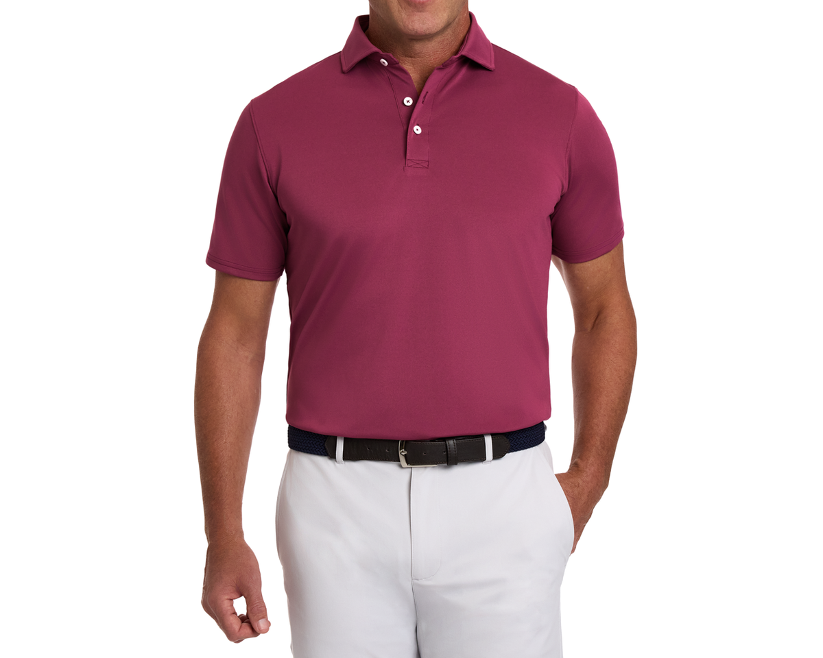 Man modeling The Macdonald Shirt: Cabernet, a short-sleeve polo with contrast collar piping, tucked into light pants, featuring a woven navy belt.