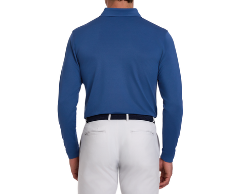Back view of a man wearing The Abbott Shirt: Andover, a long-sleeve collared polo, tucked into light trousers, with a dark woven belt.