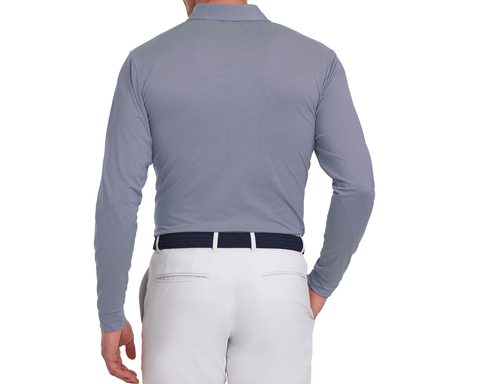 Man wearing Yale Golf Course Burke Shirt: Navy & White, showcasing fine stripes, tucked into light trousers with a woven belt, hand in pocket.