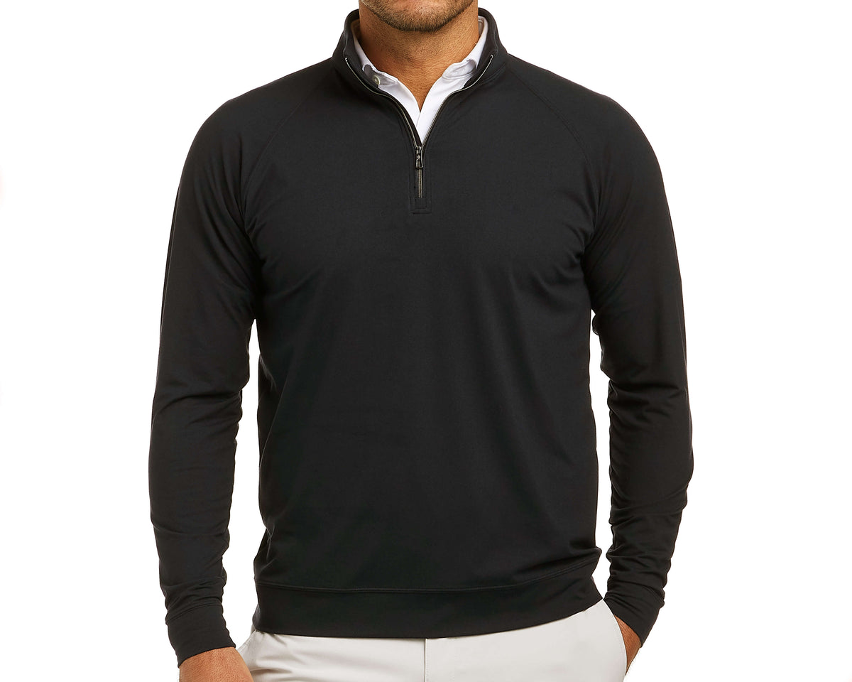 Man wearing The Westland Quarter-Zip: Black, a lightweight, technical pullover over a white shirt, featuring a quarter-zip design with gunmetal chrome trim.
