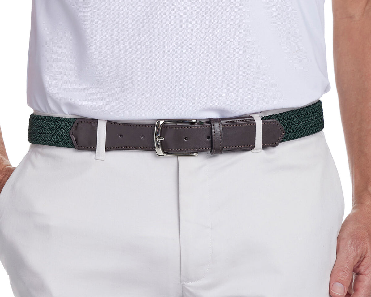 Green braided belt from Holderness and Bourne with brown leather detailing and silver buckle modeled on man wearing white.