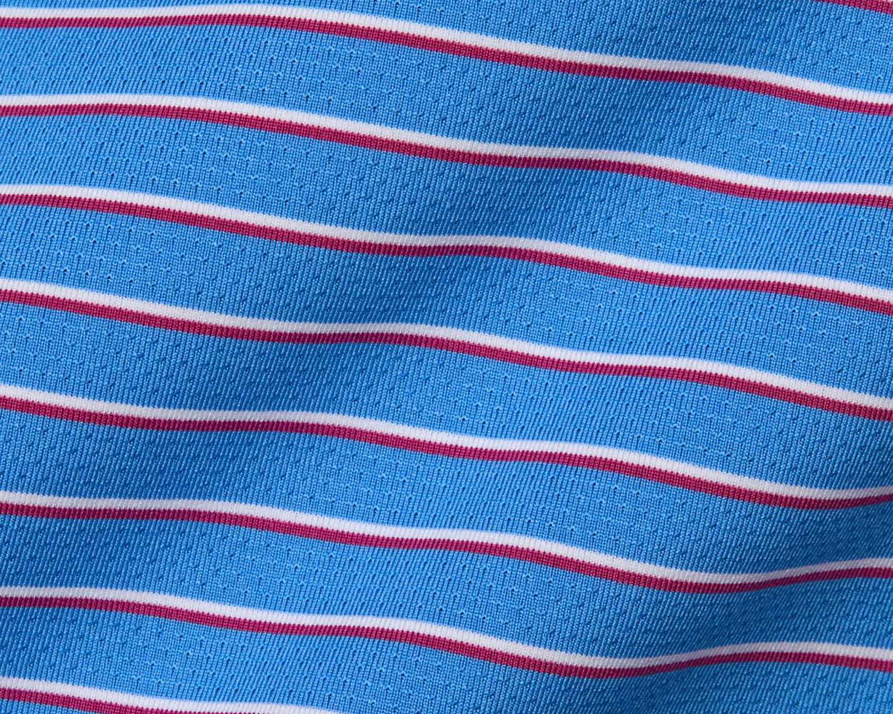 The Springer Shirt in Horizon Blue features a breathable knit fabric with red and white stripes, offering UPF 50+ protection and moisture wicking.