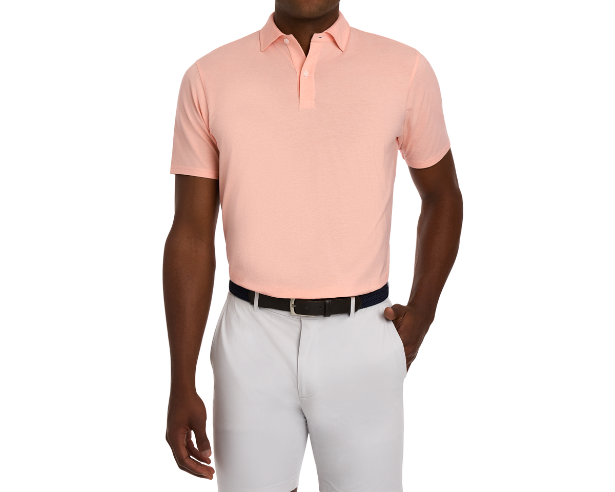 Man wearing The Hatcher Shirt: Nectarine & White, a short-sleeve polo tucked into tailored shorts, showcasing its structured collar and streamlined fit.