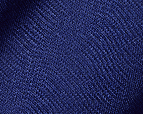Close-up of the blue knit texture of the 2026 U.S. Open Neville Shirt, showcasing its intricate stitch pattern and soft, durable cotton-elastane blend.