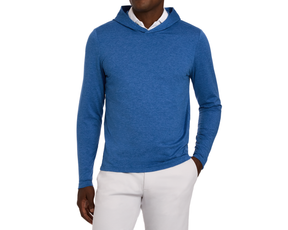 The Stowe Hoodie: Heathered Maidstone Blue, slim-fit with long sleeves, layered over a white shirt, paired with light-gray trousers, right hand in pocket.