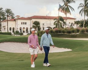 Two men on a golf course wear The Royce Quarter-Zip: Heathered Cabernet, showcasing its lightweight, stretchy design ideal for outdoor activities.