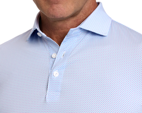 The Norman Shirt: Vista Blue & Tudor, featuring a light-colored button-up with a geometric print and classic spread collar, ideal for comfort and style on the golf course.