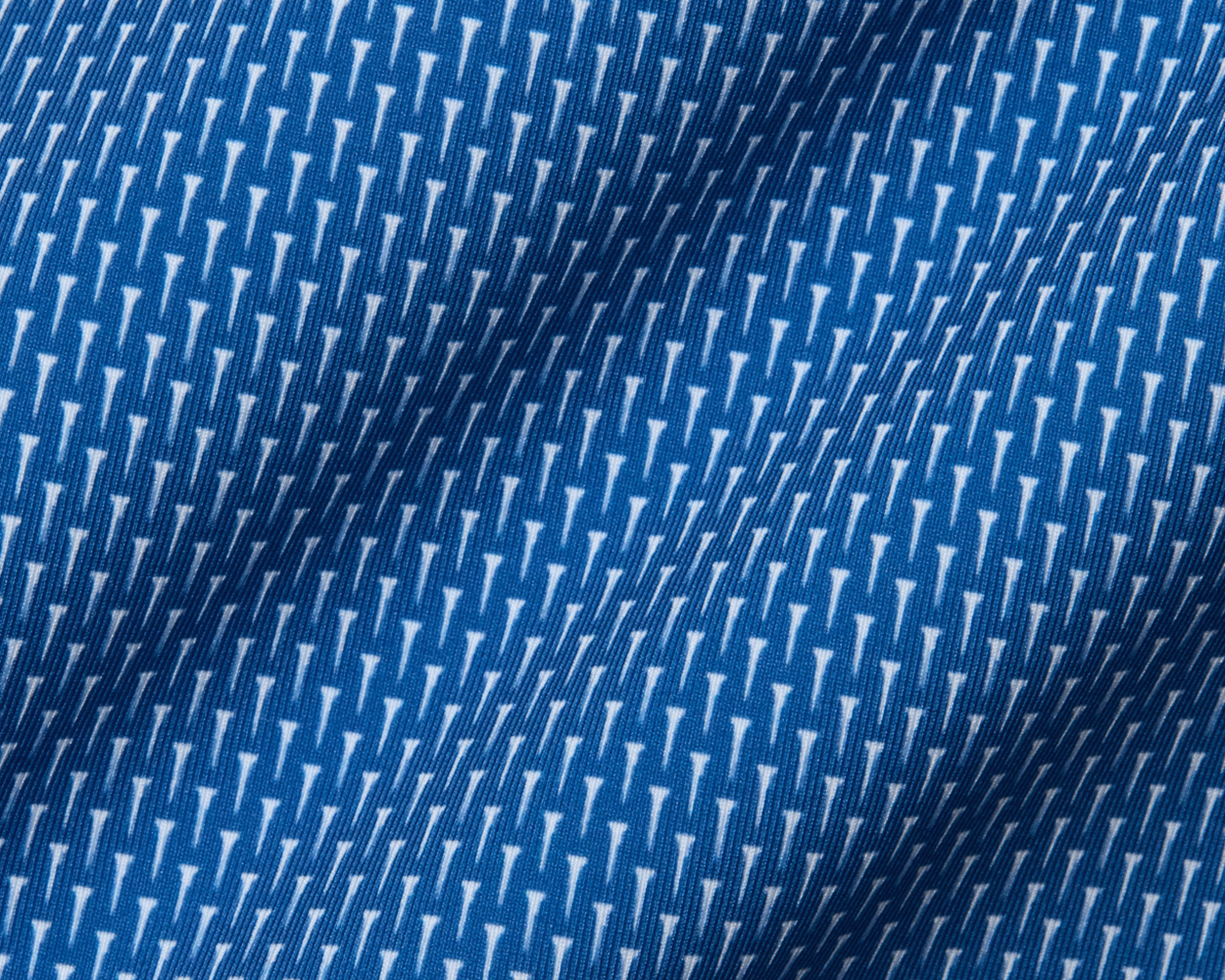 Close-up of the 2026 U.S. Open Hicks Shirt: Maidstone Blue, showcasing its blue fabric with a white geometric pattern, detailed knit texture, and gentle folds.