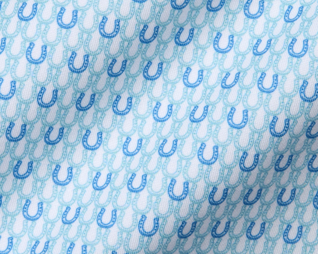 The Rivers Shirt in Harbor & Maidstone Blue features a subtle pattern of alternating dark and aqua-blue horseshoes on soft, stretchy jersey fabric.