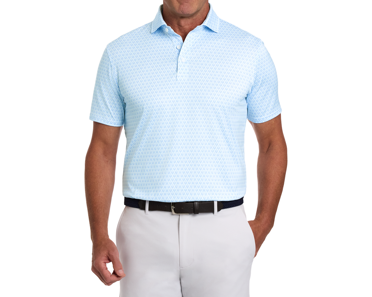 Male model wearing The Rivers Shirt: Vista Blue & Horizon Blue, featuring a subtle horseshoe pattern, tucked into light-gray chinos with a dark braided belt.