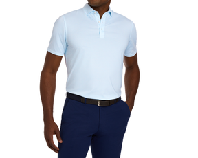 The Walton Shirt: Vista Blue on a model, showcasing its short sleeves and structured spread collar, paired with navy trousers and a black woven belt.
