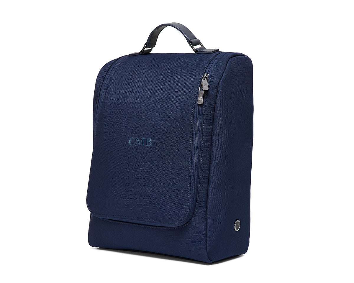 The Rutledge Shoe Bag: Navy Ballistic - Navy Embroidery, featuring a top handle, front flap pocket, zippered compartment, and side cable port, ideal for travel.