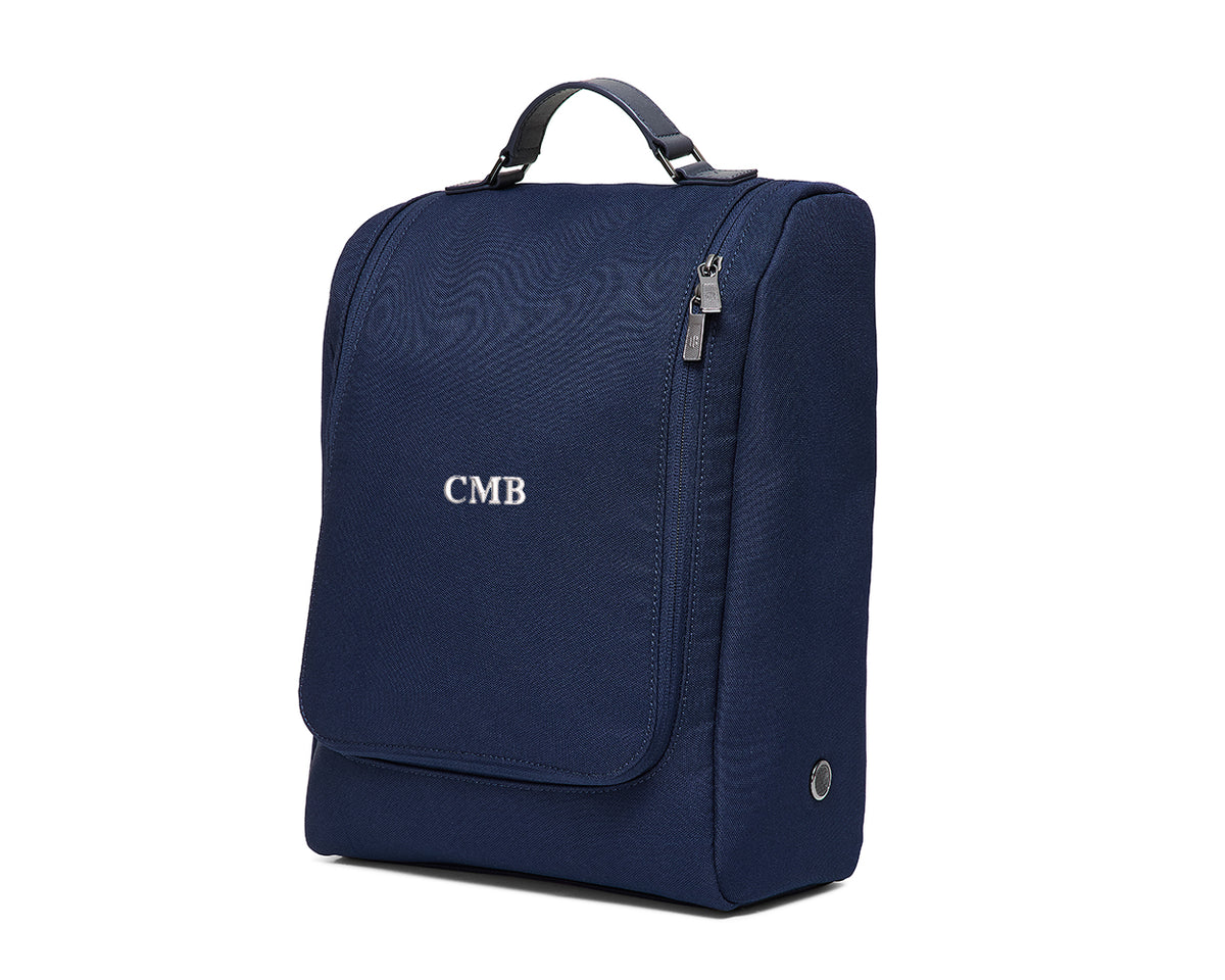 The Rutledge Shoe Bag: Navy Ballistic - White Embroidery with top handle, front flap pocket, side zippered compartment, and CMB initials embroidered on the front.