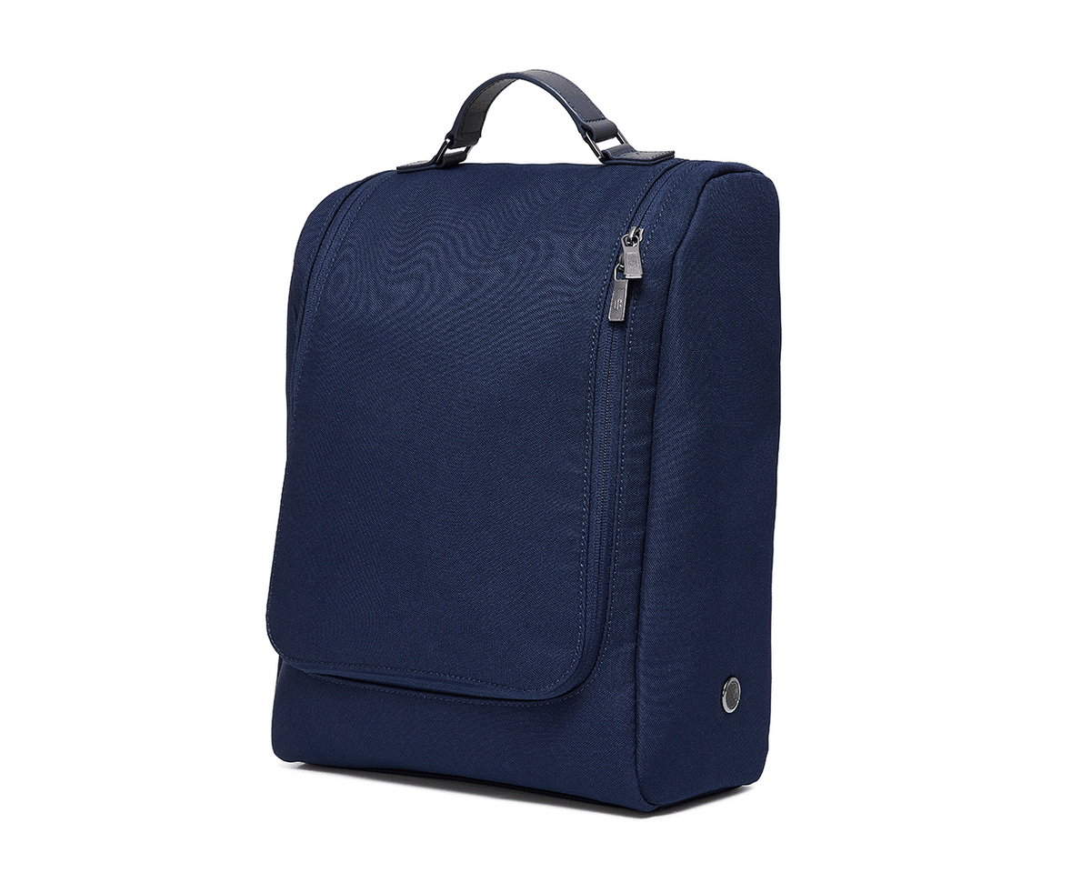 The Rutledge Shoe Bag: Navy Ballistic—a compact, navy-blue travel organizer with a top handle, zippered compartments, leather trim, and gunmetal hardware.