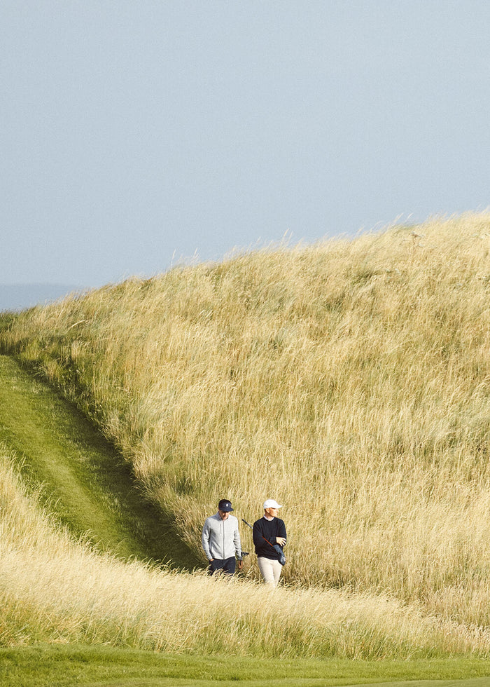 two golf players playing golf on a golf course