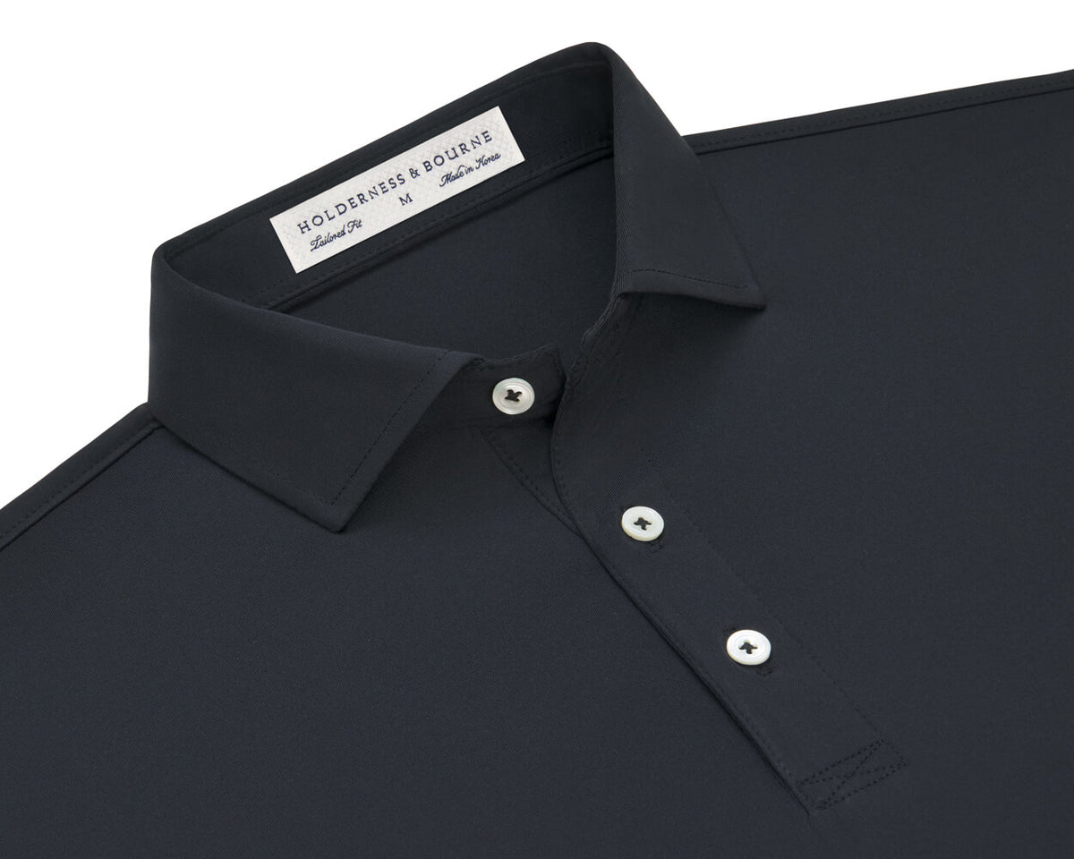 Folded Holderness and Bourne black performance polo.