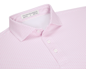 The Atwood Shirt: Belmont features a light pink, patterned polo with a spread collar, three white buttons, and a small graphic motif, perfect for versatile wear.