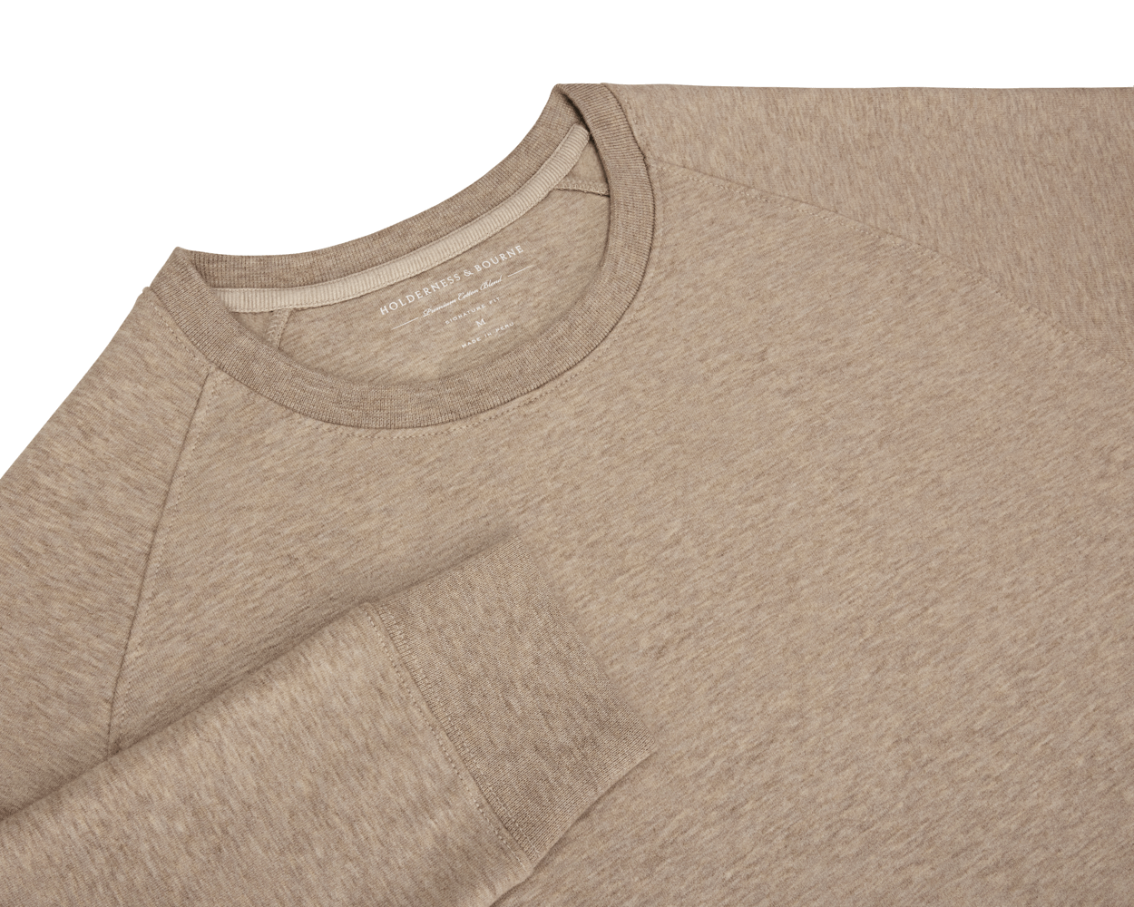 The Kennedy Crewneck: Heathered Dune features raglan sleeves, a round neckline with a printed label, and a soft, heathered cotton-blend fabric.