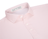 The Geiger Shirt: Nectarine, featuring a tiny orange fan motif, collared with three visible buttons, offers breathable, moisture-wicking performance pique and UPF 30+ protection.