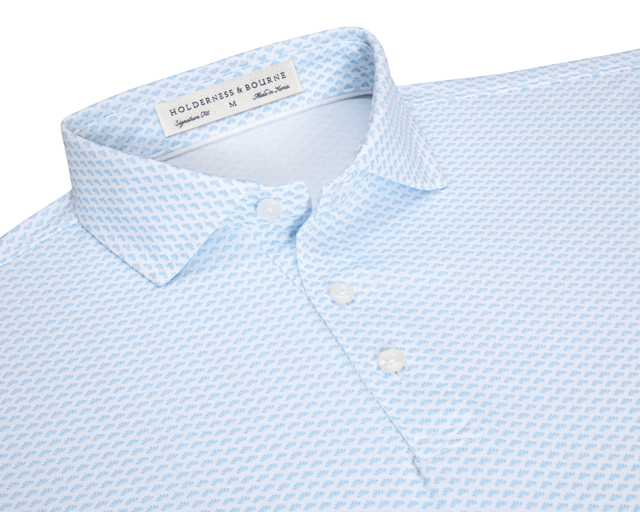 The Geiger Shirt: Vista Blue features a light-blue knit with a shell pattern, two-button placket, and spread collar, offering breathable, moisture-wicking performance.