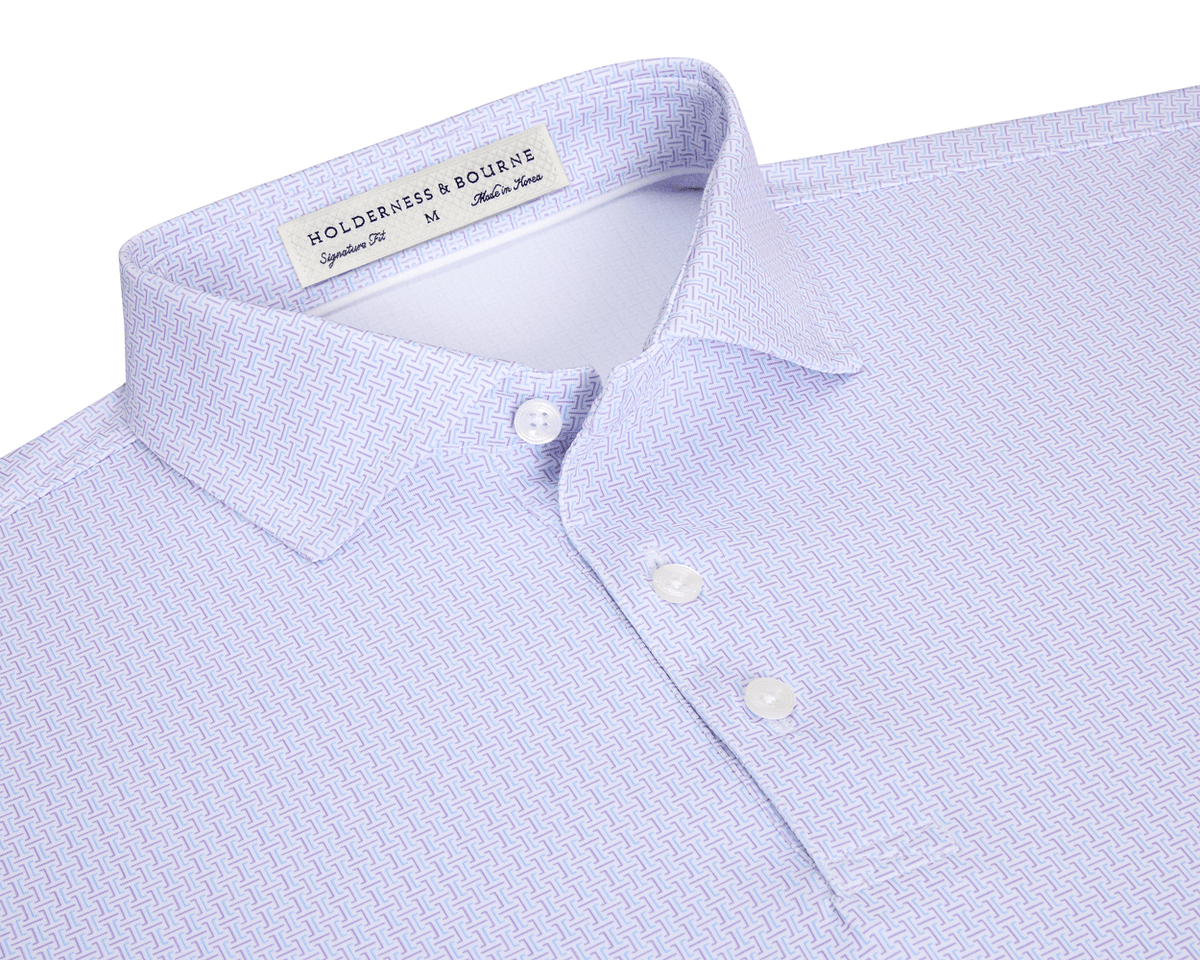The Norwood Shirt: Vista Blue & Tudor features a folded, light lavender geometric pattern, spread collar, and white buttons, offering stylish versatility and comfort.