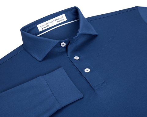 The Abbott Shirt: Andover, a long-sleeve polo featuring a collared design with white buttons, contrast collar piping, and a label reading Wilderness & Bourne, Signature Fit.