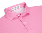 The Hicks Boys Shirt: Belmont, a pink polo with white geometric pattern, features a three-button placket, structured collar, and Holderness & Bourne label.