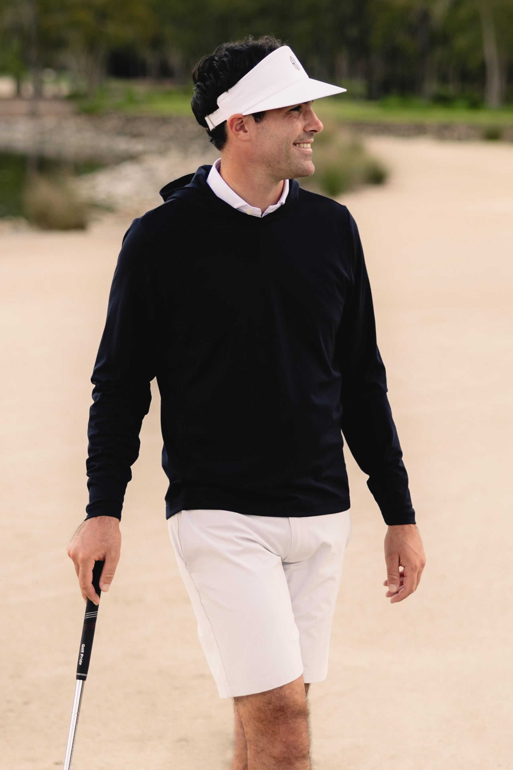 Golfer wearing black sweater and shorts