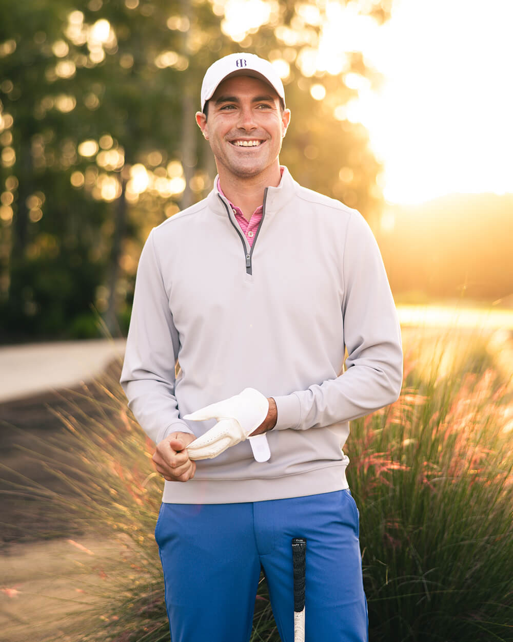 Golfer wearing a grey pullover and blue pants