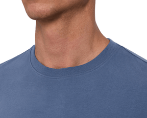 Close-up of a male model wearing The Montague Long Sleeve T-Shirt: Pacific Blue, showing the ribbed crewneck collar with a clean topstitched neckline.