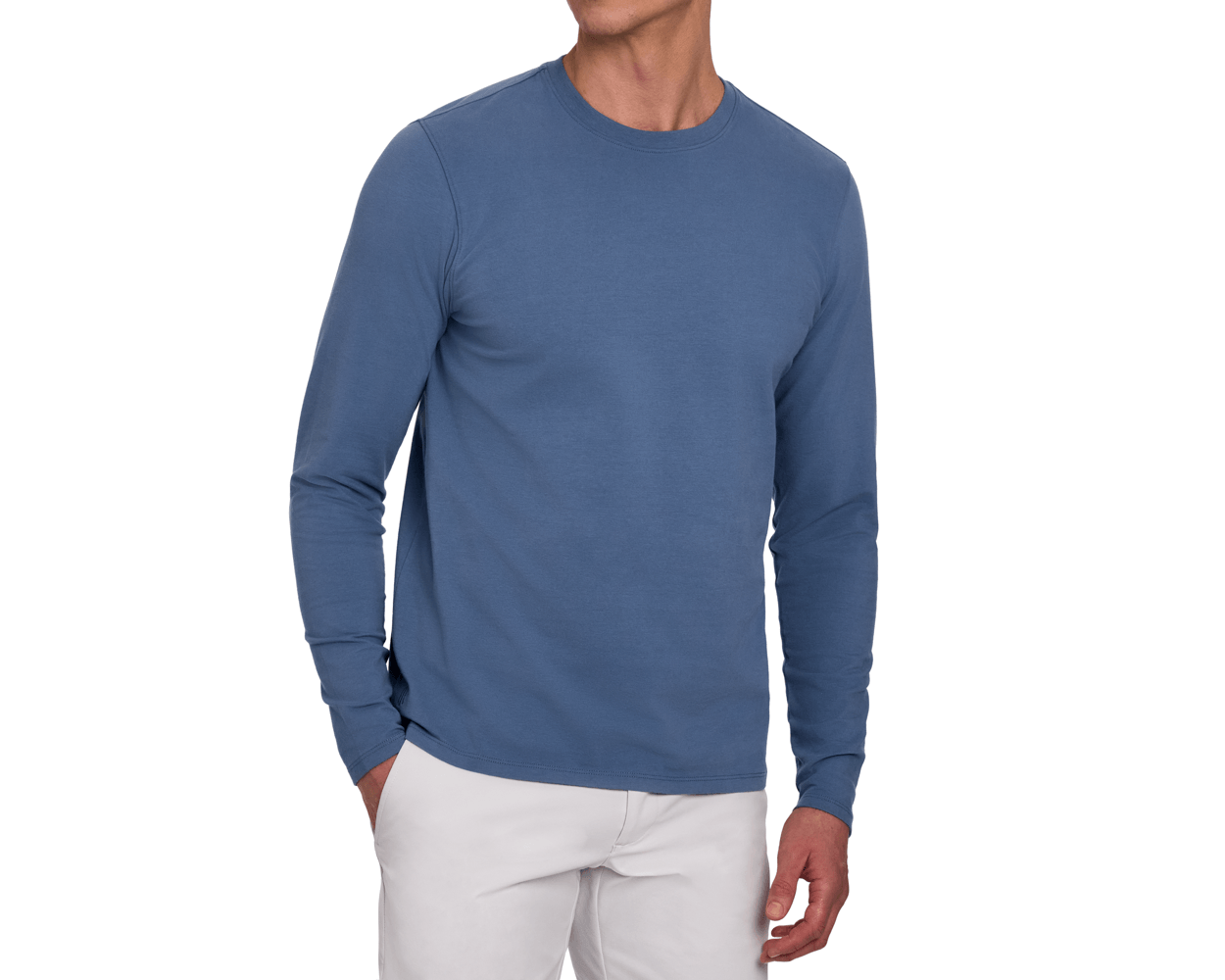 Front view of a male model wearing The Montague Long Sleeve T-Shirt: Pacific Blue, showing the classic crewneck and long sleeves, paired with light gray pants.