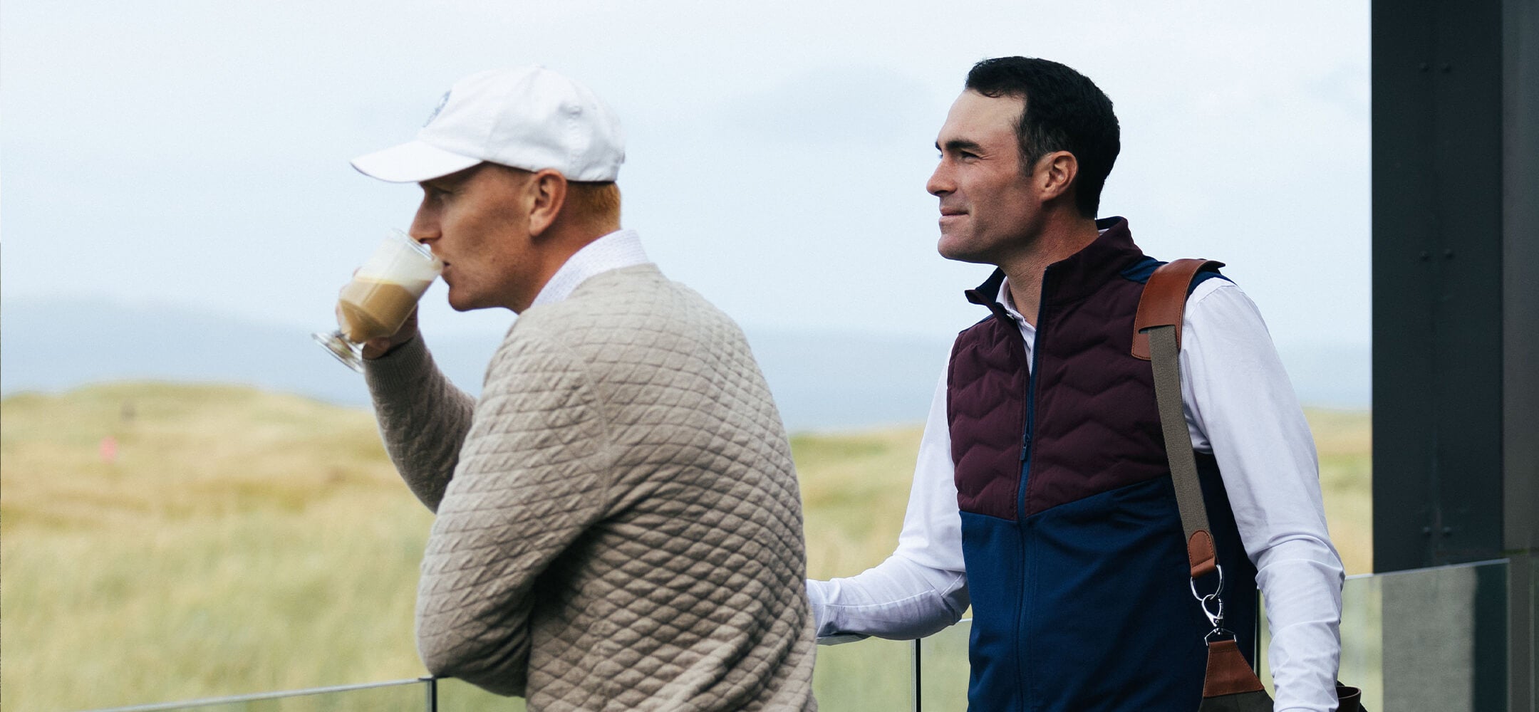 two golf players holding golf bags