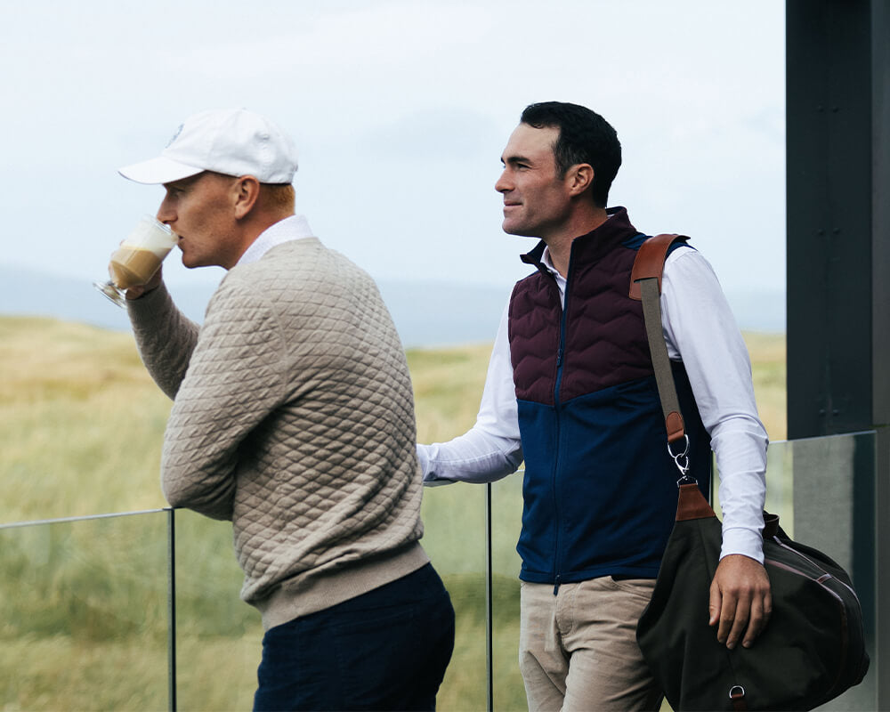 two golf players holding golf bags